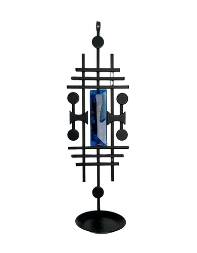 Black geometric decorative object with a blue centre on a white. Dantoft Danish Mid-Century Brutalist Candle Holder. Black Iron & Blue Glass, 1960s.background